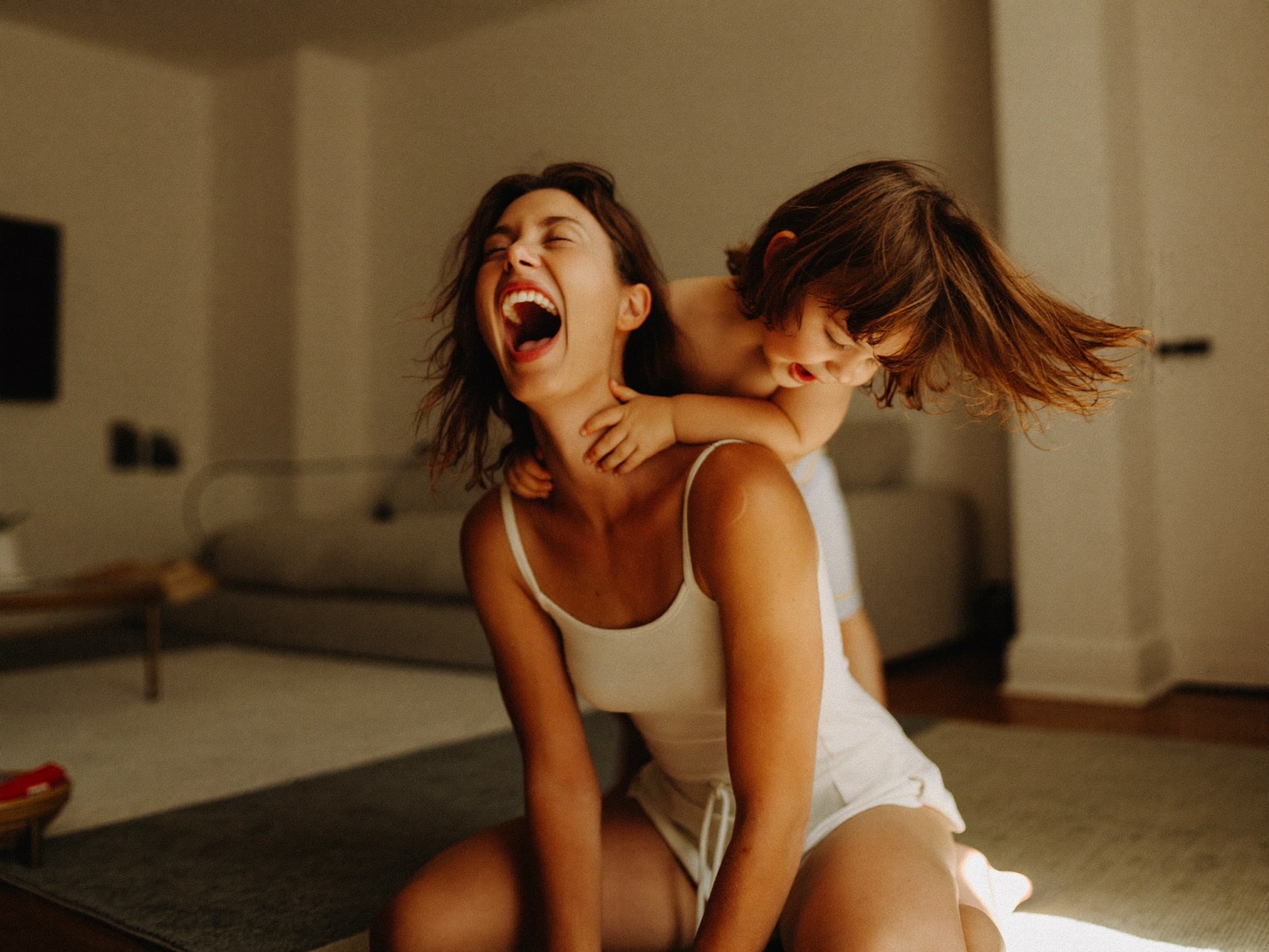 A mother laughing and playing with her child